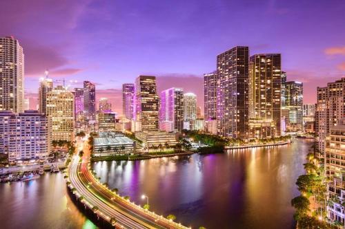 a city skyline at night with a river and buildings at Stunning Little Havana Suites Close to airport, Calle Ocho, Brickell, Wynwood and the Beaches - Free Parking in Miami