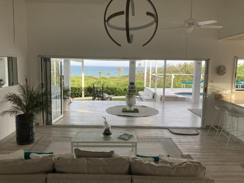 a living room with a couch and a view of the ocean at Unique Rare Villa! Retreat Style, Full Sea Views With Private Pool & Hot Tub! villa in Christ Church