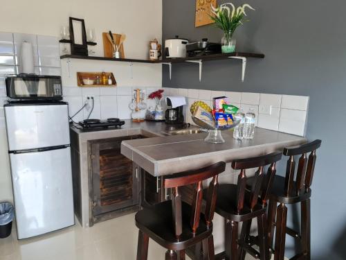 a kitchen with a counter and two bar stools at Apartamentos Ave del Paraíso in Alajuela City