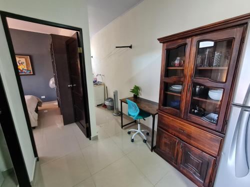 a room with a wooden cabinet and a table and a chair at Apartamentos Ave del Paraíso in Alajuela City
