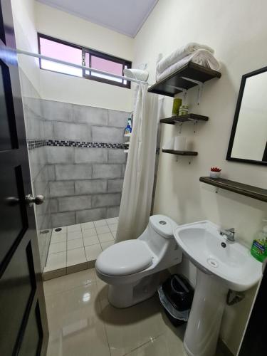 a bathroom with a toilet and a sink and a shower at Apartamentos Ave del Paraíso in Alajuela City