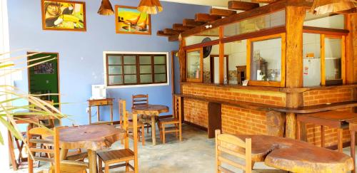 een restaurant met houten tafels en stoelen in een kamer bij Pousada Villa Maritima in Trindade