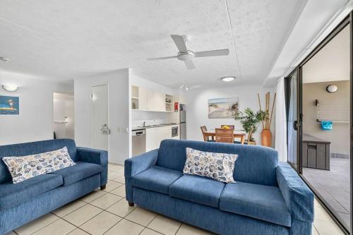 sala de estar con 2 sofás azules y cocina en Your place. Enjoy the beach retreat, en Rainbow Beach