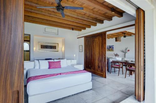 a bedroom with a bed and a dining room at Las Palmas Luxury Villas in Zihuatanejo