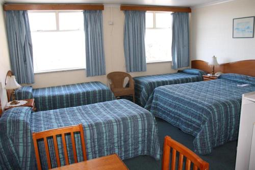 a hotel room with two beds and a table at Marquis Hotel Motel in Hobart