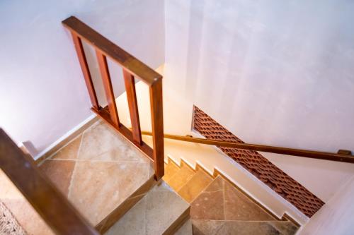 a staircase with wooden railings and tile floors at Acoara Beco Doce in Jericoacoara