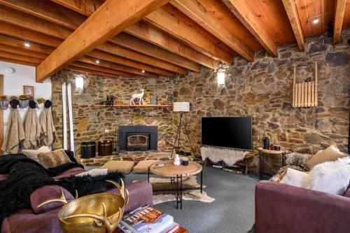 a living room with a stone wall at Croajingalong in Dinner Plain
