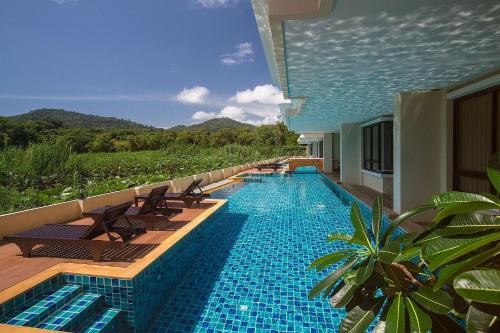 a swimming pool with chairs and a resort at LAGO APARTMENTS BY TROPICLOOK in Nai Harn Beach