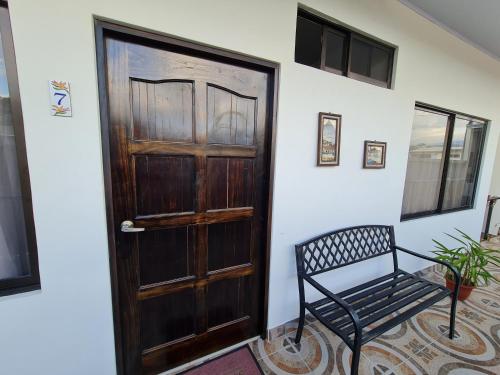 a wooden door and a bench in a room at Apartamentos Ave del Paraíso in Alajuela City
