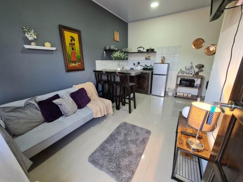 a living room with a couch and a kitchen at Apartamentos Ave del Paraíso in Alajuela City