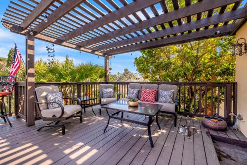 a deck with a pergola and chairs and a table at Canyon Palms in San Diego