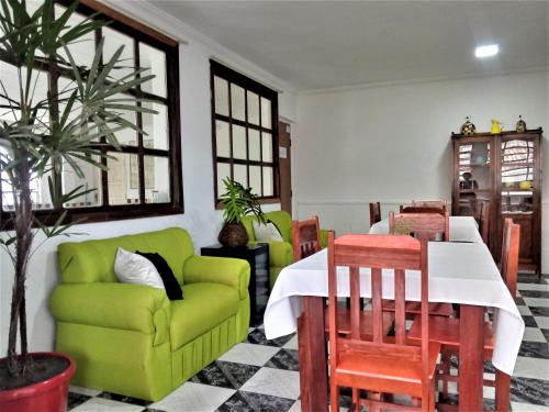 un soggiorno con tavolo e divano verde di Soledade Pousada e Apart Hotel a Morro do Chapéu