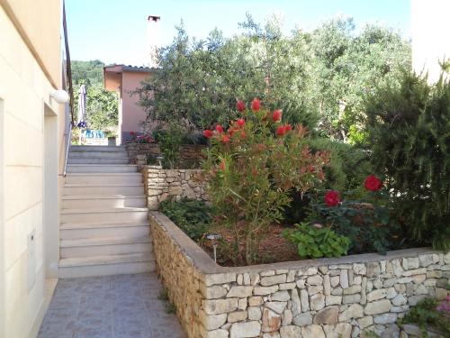 a garden with a stone retaining wall and stairs at Apartment Ana in Kali