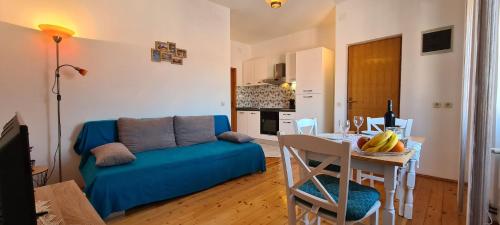 a living room with a blue couch and a table at Apartment Turan in Jelsa
