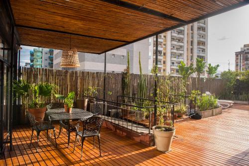 a patio with a table and chairs on a deck at La Casa de Bulnes in Buenos Aires