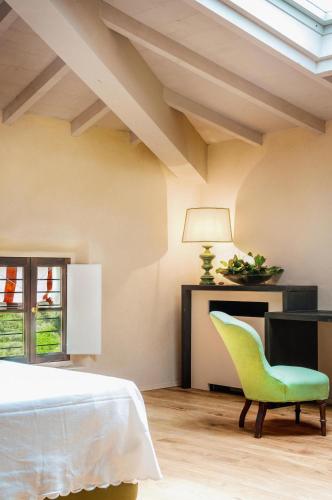 a bedroom with a bed and a green chair at Prati Palai in Bardolino
