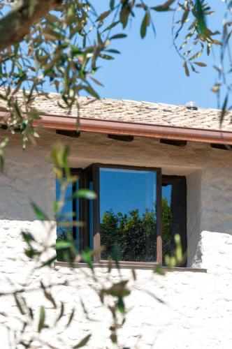 a window on the side of a house with a mirror at Prati Palai in Bardolino