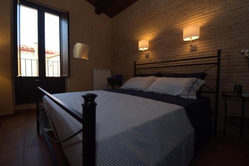 a bedroom with a bed and a brick wall at Antichi Quartieri in Piazza Armerina