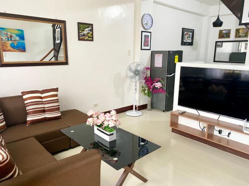 sala de estar con sofá y TV en Kaitleen Home Stay Door 1, en Tacloban