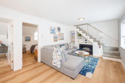 a living room with a couch and a staircase at Nantucket Penthouse - walk to restaurants beaches activies & so much more in Half Moon Bay