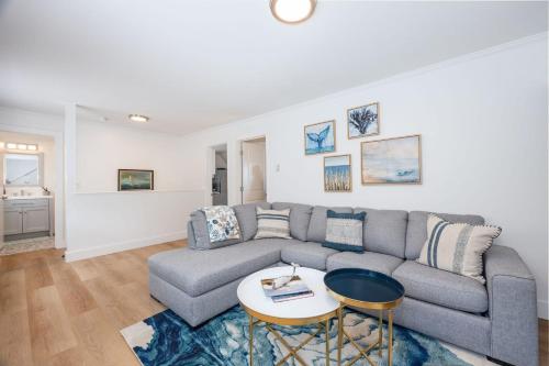 ein Wohnzimmer mit einem Sofa und einem Tisch in der Unterkunft Nantucket Penthouse - walk to restaurants beaches activies & so much more in Half Moon Bay
