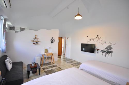 a bedroom with two beds and a tv on the wall at Sea Daughter's Homestay in Huxi