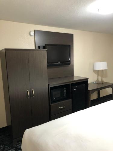 a hotel room with a bed and a tv and a cabinet at Quality Inn Cameron in Cameron