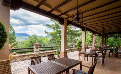 a patio with tables and chairs with a view at Hotel de Montaña Cueva Ahumada in Villaverde de Guadalimar