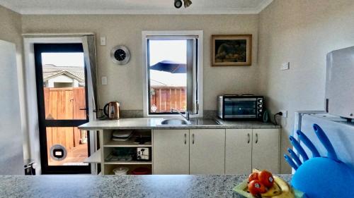 cocina con fregadero y encimera con ventana en Almost Country, en Taupo