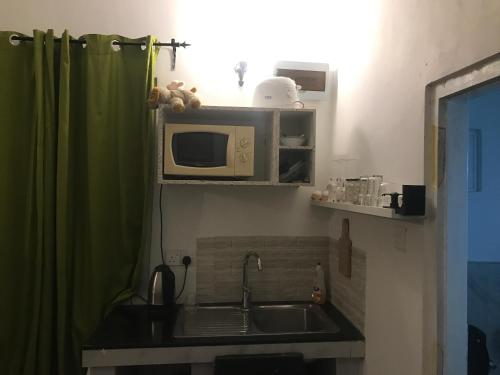 a kitchen with a sink and a microwave at White Barn Chalet in Ragama