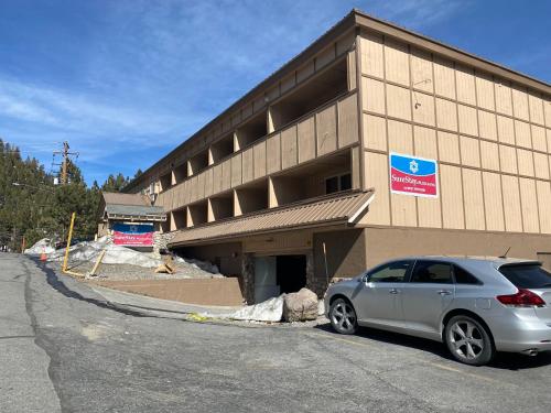 a car parked in front of a building at SureStay Plus Hotel by Best Western Mammoth Lakes in Mammoth Lakes