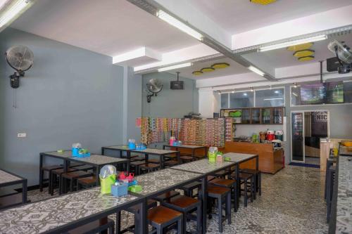a restaurant with tables and chairs in a room at RedDoorz Plus near Patung Kuda Undip in Jatingaleh