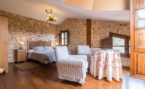 1 dormitorio con 1 cama y 2 sillas en Hotel de Montaña Cueva Ahumada, en Villaverde de Guadalimar
