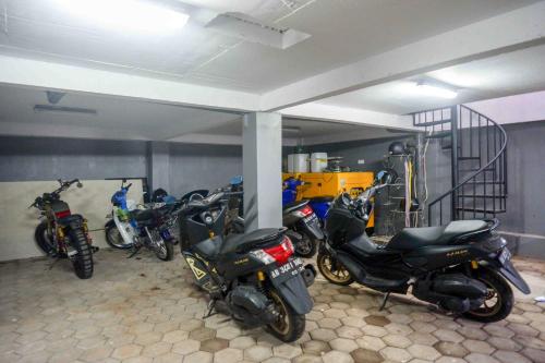 a group of motorcycles parked in a garage at RedDoorz Plus near Patung Kuda Undip in Jatingaleh