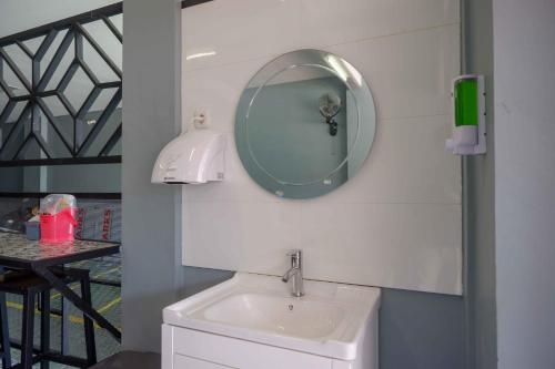 a bathroom with a sink and a mirror on the wall at RedDoorz Plus near Patung Kuda Undip in Jatingaleh