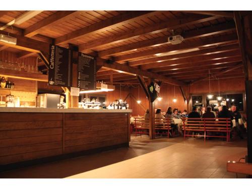 a restaurant with a bar with people sitting at tables at Rifugio 2000 in Alpe Ciamporino