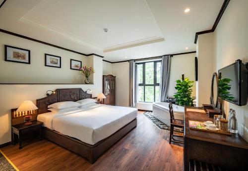 a bedroom with a large bed and a television at Amanaki Saigon Boutique Hotel in Ho Chi Minh City