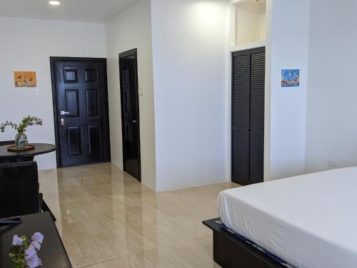 a bedroom with a bed and black doors and a table at Inn The Town in Port Antonio