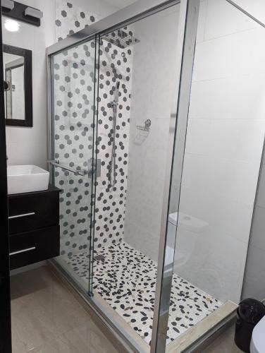 a shower with a glass door in a bathroom at Inn The Town in Port Antonio