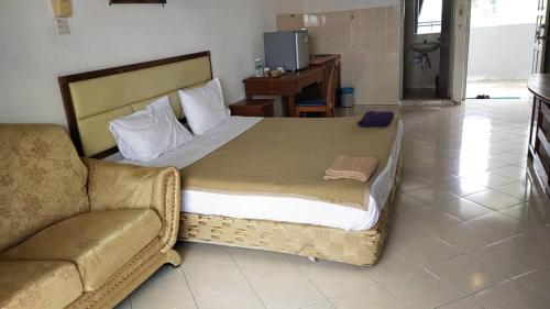 a bedroom with a large bed and a couch at Marina Cove Resort in Lumut