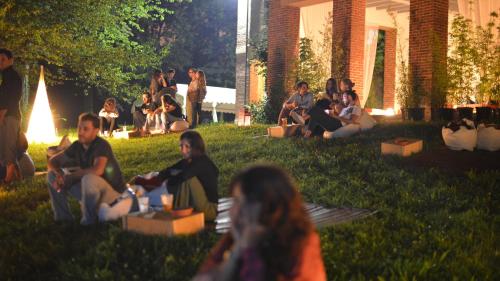 a group of people sitting in the grass at B&B e Ostello, Parco di Monza, CASCINA COSTA ALTA in Monza