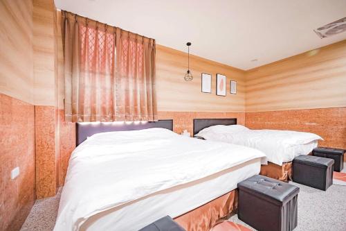 two beds in a room with wood paneling at All Want Stay in Ch'ang-p'ing