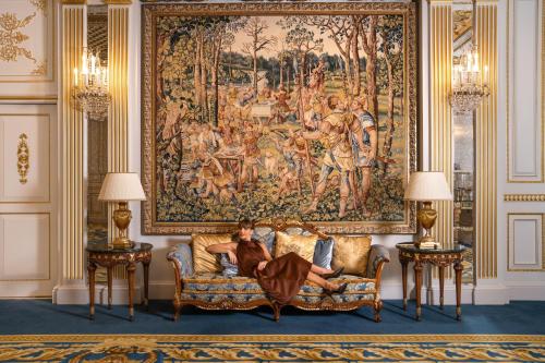 a living room filled with furniture and a painting on the wall at Raffles The Palm in Dubai