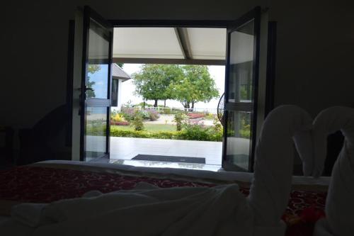 a bedroom with a window looking out at a garden at Lander's Bay Resort in Lautoka
