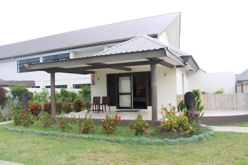 a white house with a porch and some flowers at Lander's Bay Resort in Lautoka