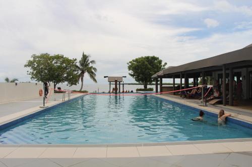a large swimming pool with two children in the water at Lander's Bay Resort in Lautoka