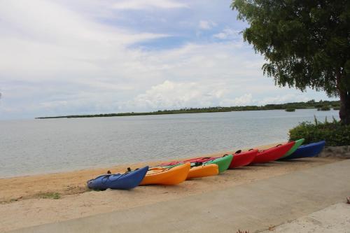 a row of kayaks lined up on a beach near the water at Lander's Bay Resort in Lautoka