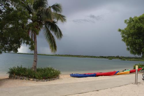 a group of kayaks on the beach next to the water at Lander's Bay Resort in Lautoka