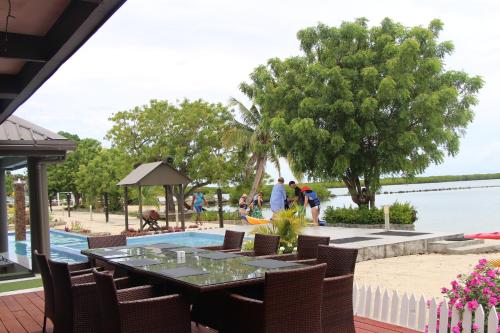 a patio with a table and chairs next to a pool at Lander's Bay Resort in Lautoka
