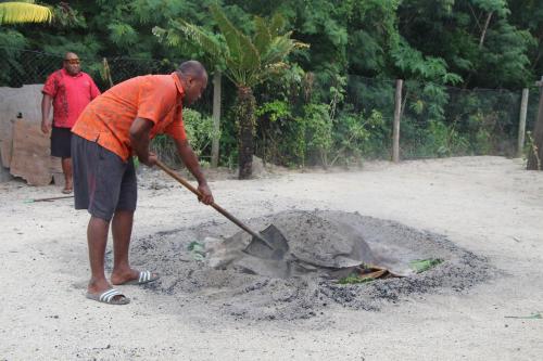 a man is digging a dead animal with a shovel at Lander's Bay Resort in Lautoka